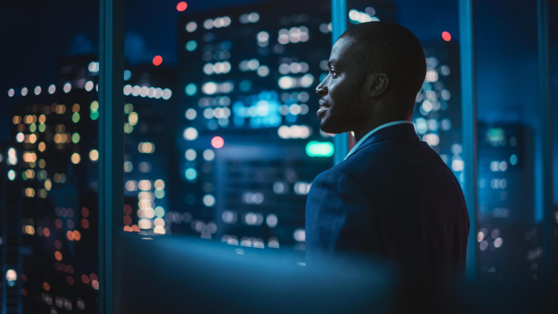 A man overlooking a city from an office.